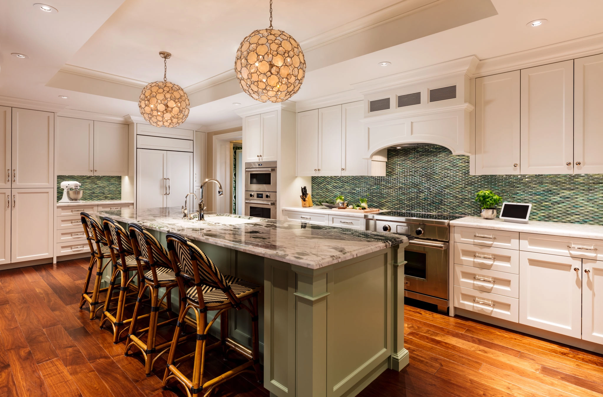 Stunning Kitchens with multi-colored green tile backsplashes and off white cabinetry are our favorite. In the middle of the kitchen, there is a large olive green island with a marble countertop.